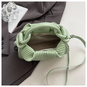 Detail of light green pleated handbag showing inner lining and magnetic metal closure