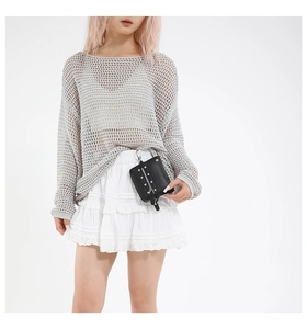 Detail of black pebbled leather waist bag with silver studs on white dress