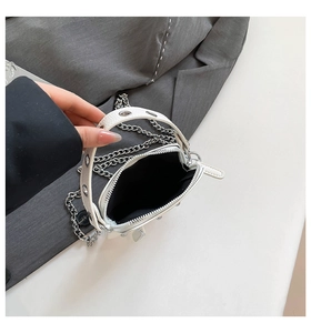 Detail of white studded handbag featuring lychee grain leather and silver chain strap
