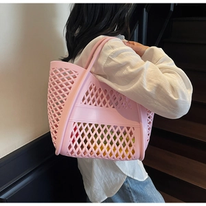 Détail du sac cabas rose ajouré montrant le motif géométrique et la texture souple