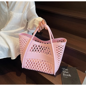 Sac cabas ajouré en silicone rose avec double anse présenté dans un cadre de vie