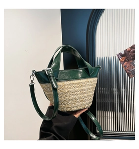 Detail of green leather and straw woven bucket bag with detachable shoulder strap