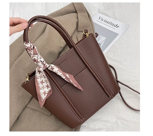 Detail of dark brown pebble leather tote bag with a chic houndstooth silk scarf on handle