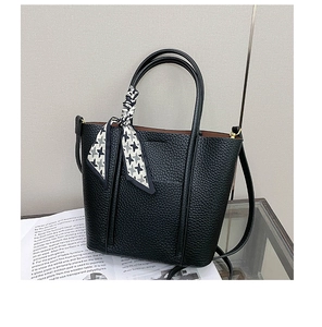 Detailed close-up of a black lychee texture tote bag with a decorative houndstooth silk scarf