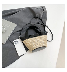 Detailed top view of a woven bucket bag with black leather trim and adjustable strap
