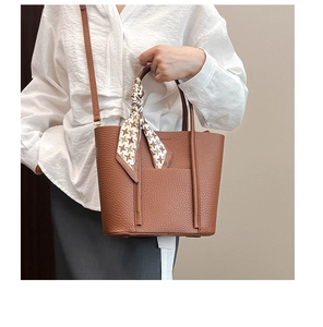 Brown litchi grain leather tote with decorative houndstooth scarf on top handle