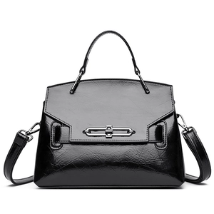 Sac à main trapèze noir brillant avec boucle argentée et bandoulière réglable