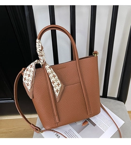 Detail of caramel leather tote bag with houndstooth silk scarf and gold hardware