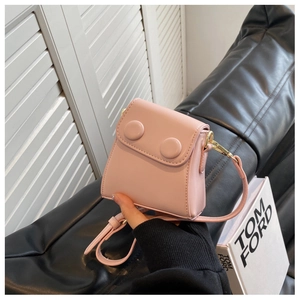 Gros plan du mini sac bandoulière en cuir rose avec boutons décoratifs et métal doré