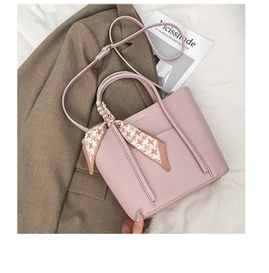 Detail of pink lychee grain leather tote bag with elegant houndstooth scarf ornament
