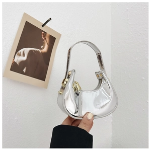 Detail of silver crescent mini bag with shiny metallic finish and gold zipper closure