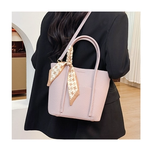 Detailed close-up of lilac lychee grain leather tote bag with stylish houndstooth scarf
