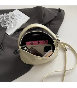 Interior view of off-white crossbody bag showing space for phone and makeup