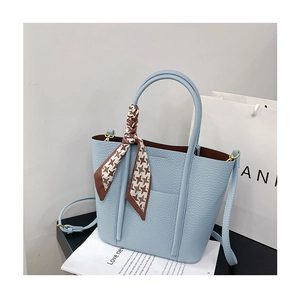 Detail of light blue pebble leather tote bag with houndstooth silk scarf and long strap