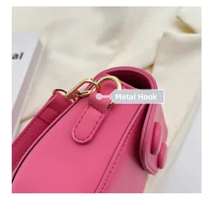 Gros plan détaillé du mini sac rose fuchsia avec crochet doré poli et texture en cuir