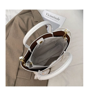 Interior view of white lychee leather tote bag showing compartments and golden hardware