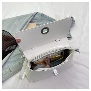 Vue détaillée du sac à bandoulière blanc avec compartiments internes et fermoir rotatif