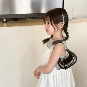 Mini black patent leather crescent bag detail on model for a trendy summer look