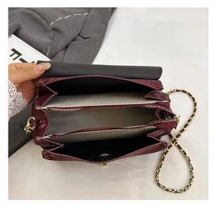 Detailed interior of snakeskin embossed handbag showing multi-compartment storage space