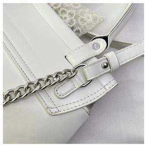 Détail d'un sac en similicuir blanc avec chaîne argentée et boucle à rivets sur la bandoulière