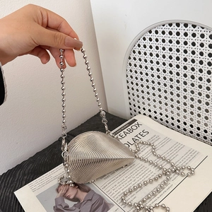 Silver metallic shell clutch bag with beaded handle and ribbed texture for evening wear