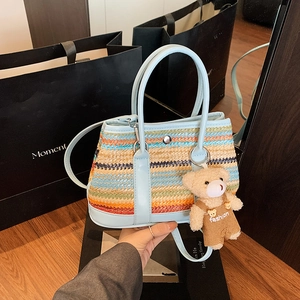 Colorful striped woven tote bag with blue leather straps and a cute bear charm