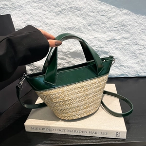 Green leather and straw woven bucket bag with dual handles and detachable shoulder strap