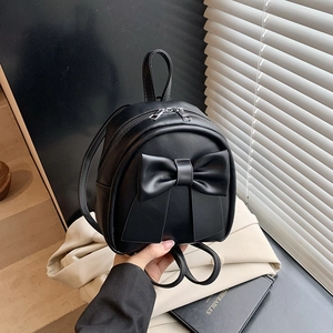 Chic black mini faux leather backpack featuring a large bow and silver dual zippers