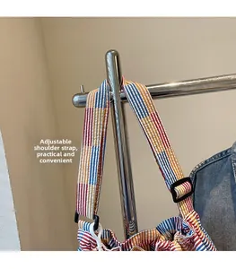 Detail view of adjustable canvas shoulder strap with buckle for the striped crossbody bag