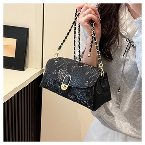 Close-up of black snakeskin texture shoulder bag with gold chain and metal clasp