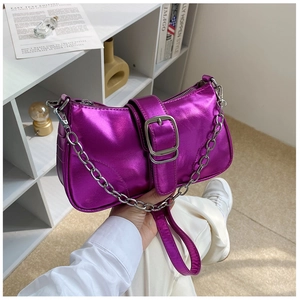Dettaglio borsa a spalla in vernice viola con catena argentata e fibbia metallica