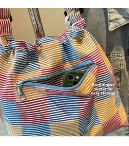 Close-up of the back zipper pocket on the striped canvas bag storing a smartphone