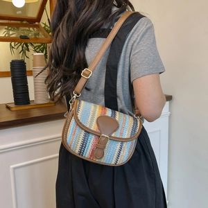 Detail of colorful striped straw crossbody bag with brown leather strap and metal buckle
