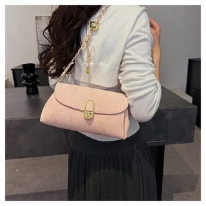 Detailed view of pink snake-embossed shoulder bag with gold chain and metal twist lock