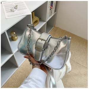 Dettaglio della borsa a mezzaluna argento metallizzato con catena spessa e fibbia decorativa