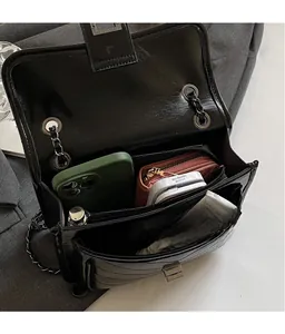 Close-up of black quilted leather bag interior showing spacious compartments and items