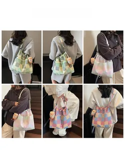 Detail view of large canvas drawstring shoulder bag with plaid pattern and plush charm