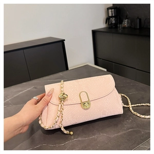 Close-up of pink snakeskin pattern bag with round gold metal lock and chain strap