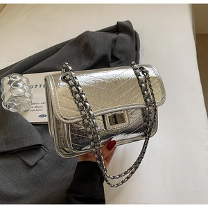 Detail of silver metallic quilted bag with bronze twist lock and chain strap