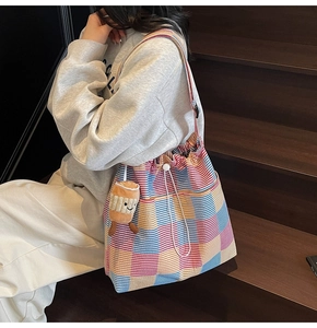 Detail of colorful striped canvas tote bag with drawstring and cute plush coffee cup charm