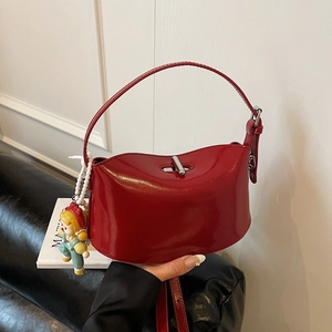 Glossy red patent leather crossbody handbag with silver twist lock and doll charm