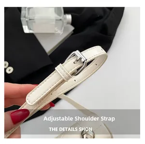 Detail of adjustable cream leather strap with silver buckle on a vintage handbag