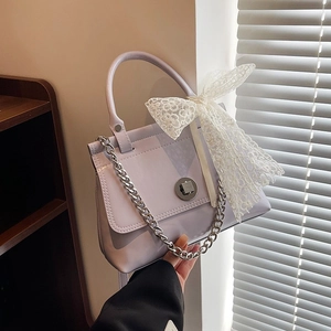 Sac à main lilas en cuir verni avec nœud en dentelle et chaîne en argent