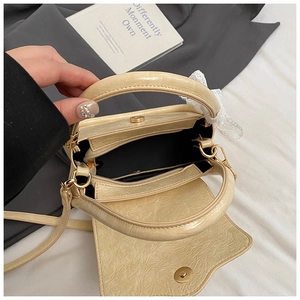Internal view of cream saddle bag featuring magnetic buckle and zip pocket detail
