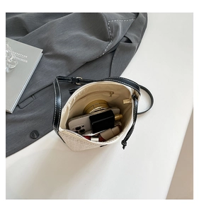 Top view of bucket bag interior showing spacious storage with straw and leather details