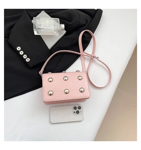 Pink quilted crossbody bag with silver studs and white smartphone for size reference