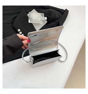 Top view of shiny silver metallic bag with magnetic flap closure and black lining