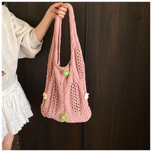 Detail of pink woven tote bag featuring 3D floral accents and knit texture for women