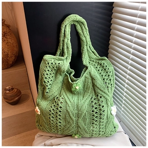 Détails macro d'un sac cabas vert en maille avec fleurs de marguerite au crochet