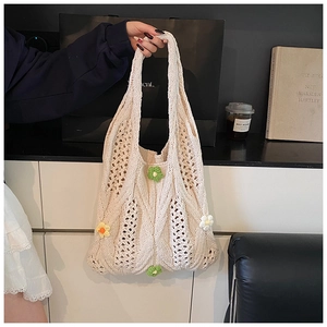 Détail d'un sac à main en tricot crème avec des fleurs crochetées en 3D et une maille ajourée